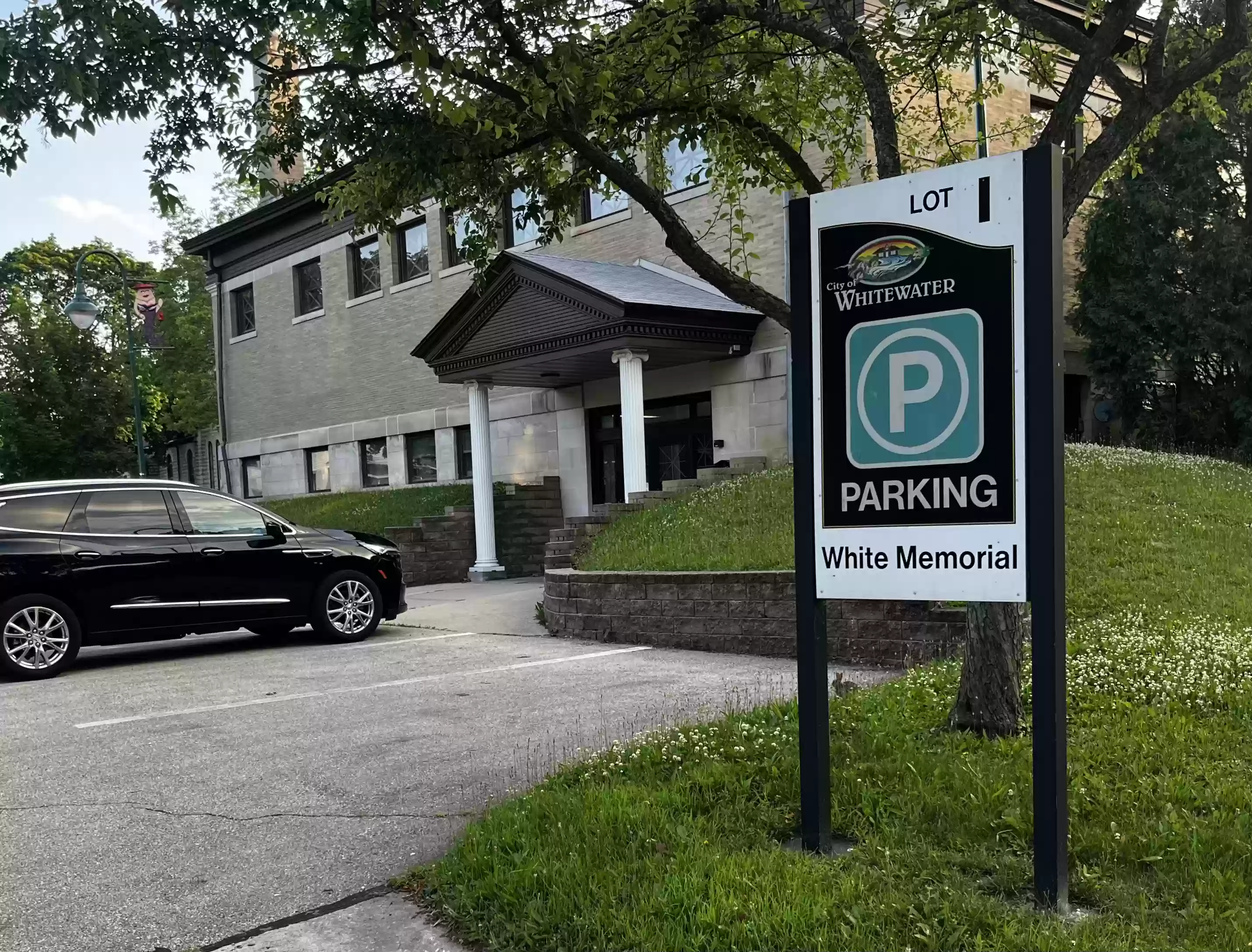 White Memorial parking sign with building in the background
